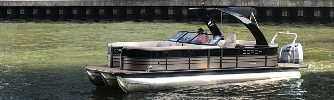 A man floating in a Coach Pontoon within the canal of a river.