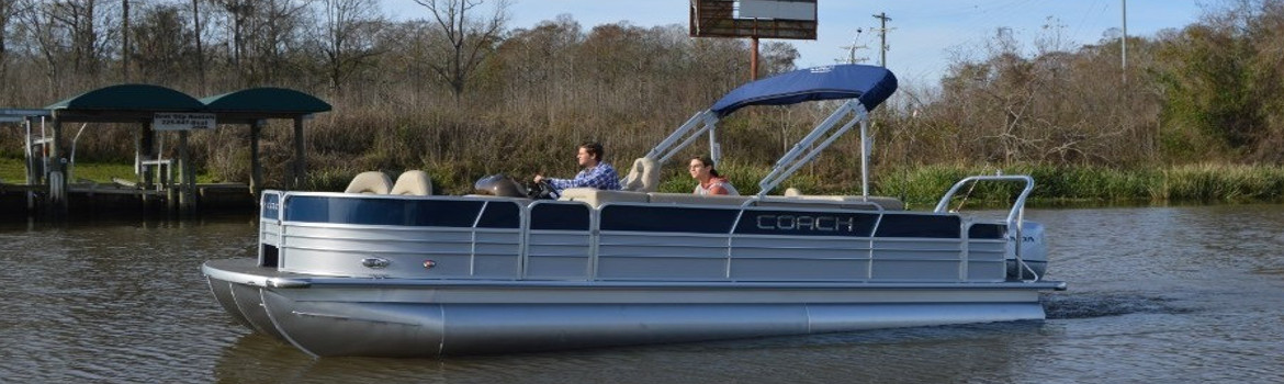 Two individuals cruising on a Coach Pontoon in the Fall.